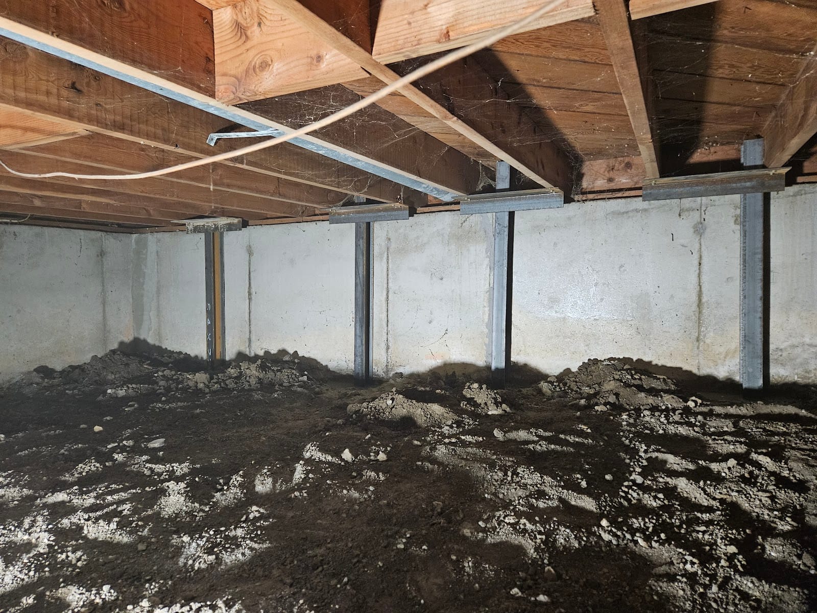 Basement with steel support beams and posts installed along the walls