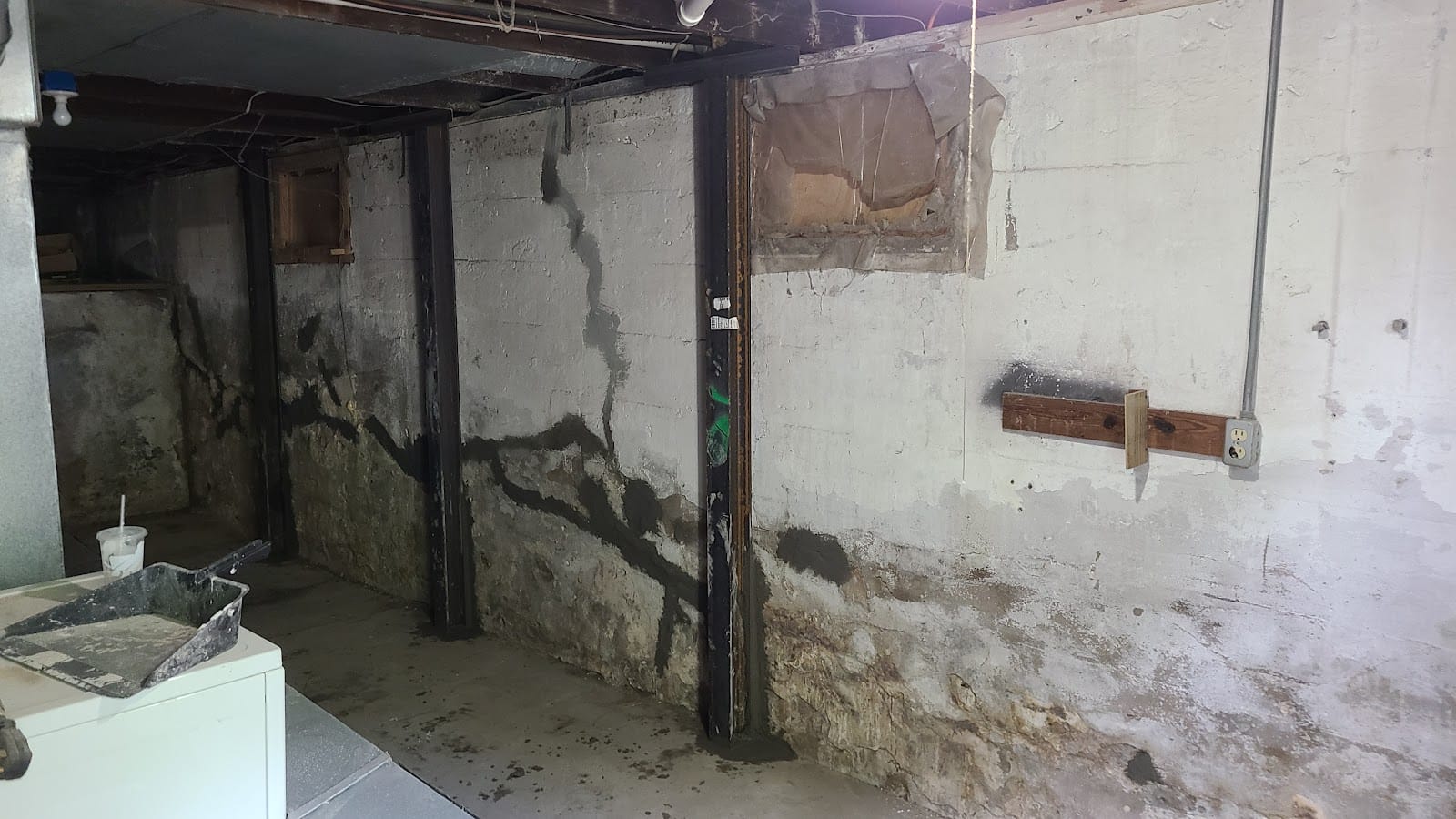 Interior foundation wall repair with steel support jacks in a Kansas City basement