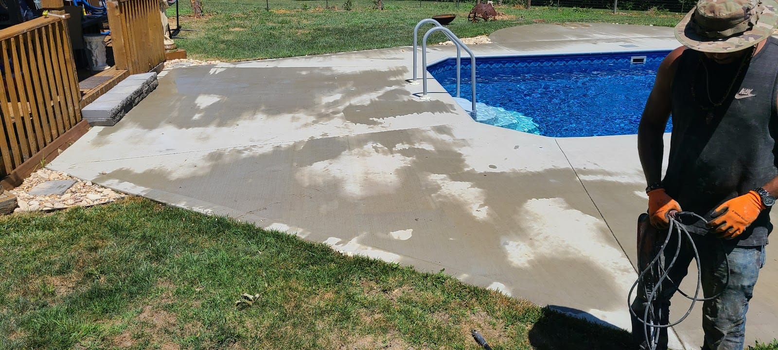 Concrete pad finished beside a backyard swimming pool
