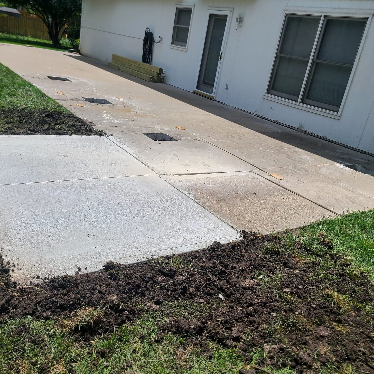 New concrete walkway beside a house after foundation work